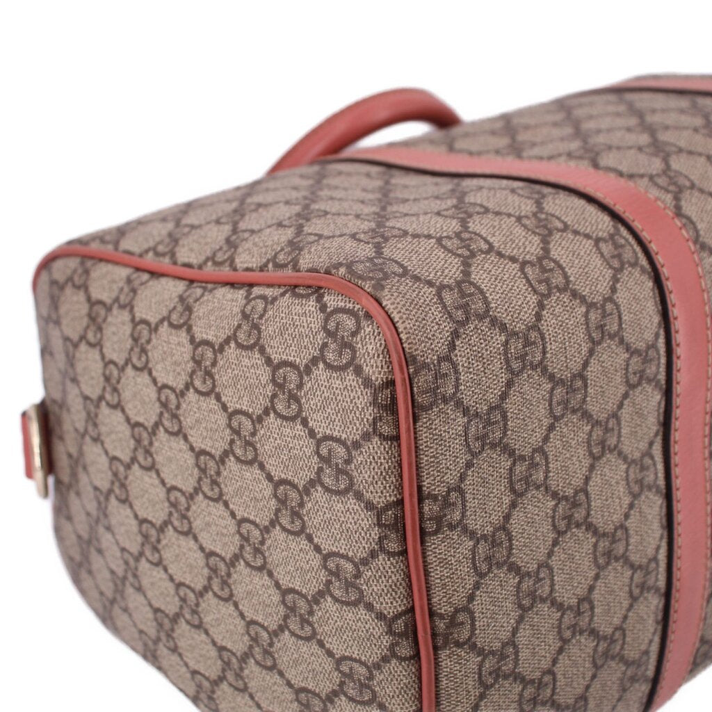GUCCI Boston handle bag side close-up, tan GG canvas with rose edge piping and stitching.