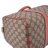 GUCCI Boston handle bag side close-up, tan GG canvas with rose edge piping and stitching.