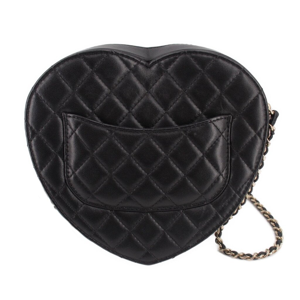 Black quilted heart crossbody bag back view with stitched leather panel and chain.
