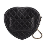 Black quilted heart crossbody bag back view with stitched leather panel and chain.