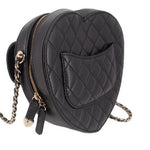 Black quilted heart crossbody bag side view with gold zipper pull and strap ring.