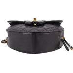 Black quilted heart crossbody bag top view with gold snap hardware and chain.