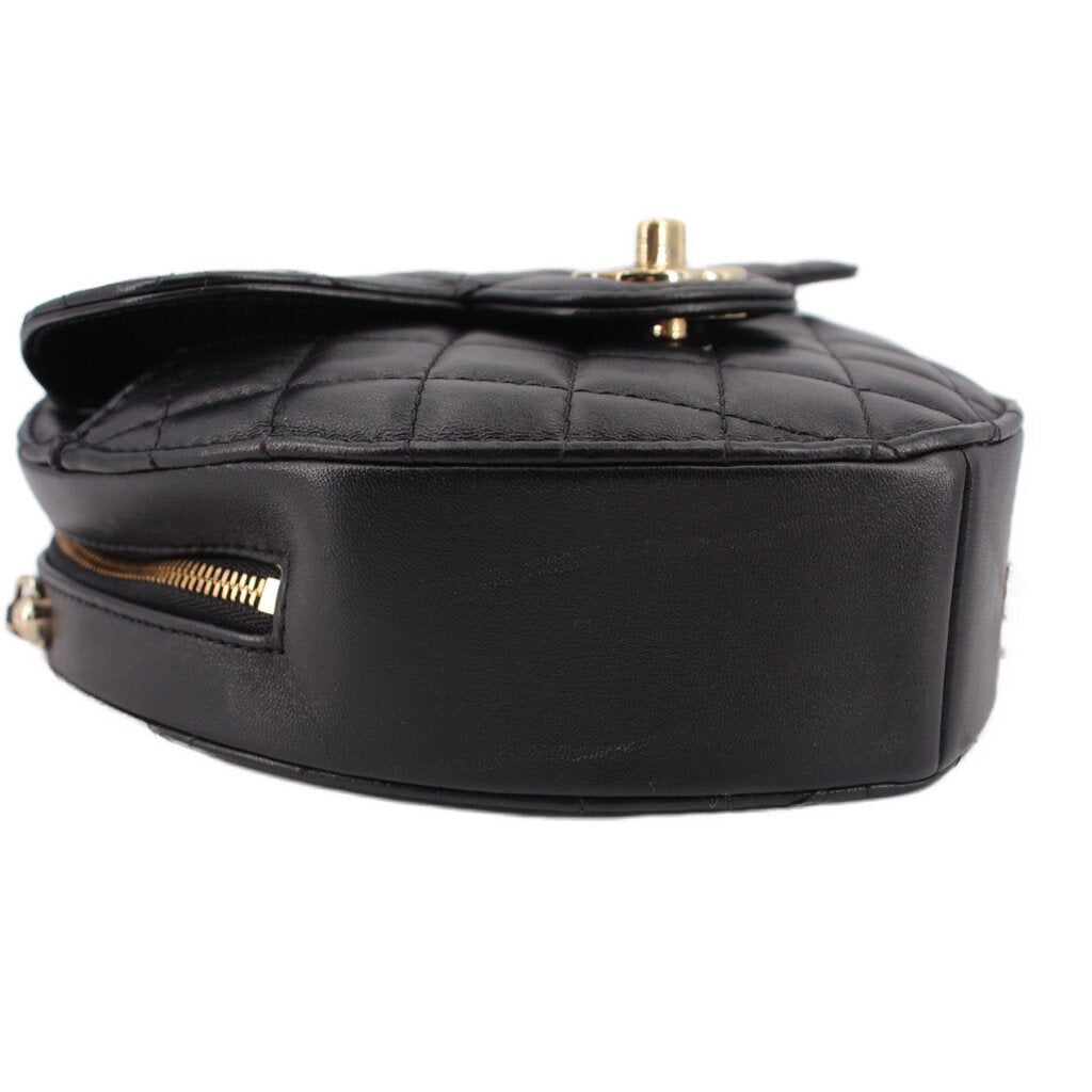 Black quilted heart crossbody bag side view with gold top hardware and chain.