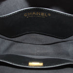 Black fabric-lined interior of crossbody bag with CHANEL logo stamp.
