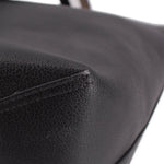 Black reversible tote bag corner close-up with curved seam stitching.