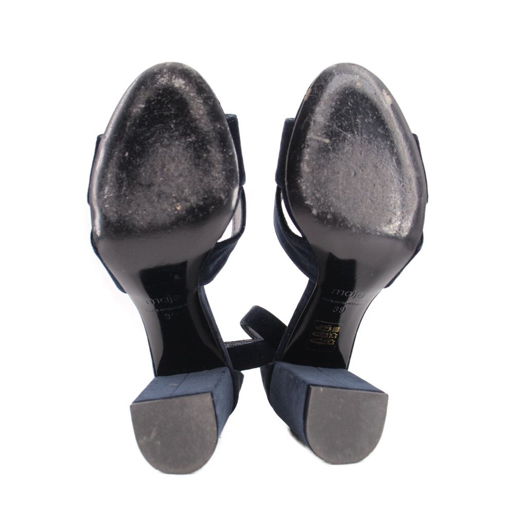 Underside view of navy suede heeled sandals with metal heel soles