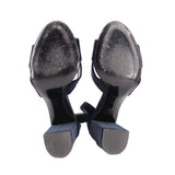 Underside view of navy suede heeled sandals with metal heel soles