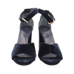 Pair of navy suede heeled sandals with ankle straps and gold buckles