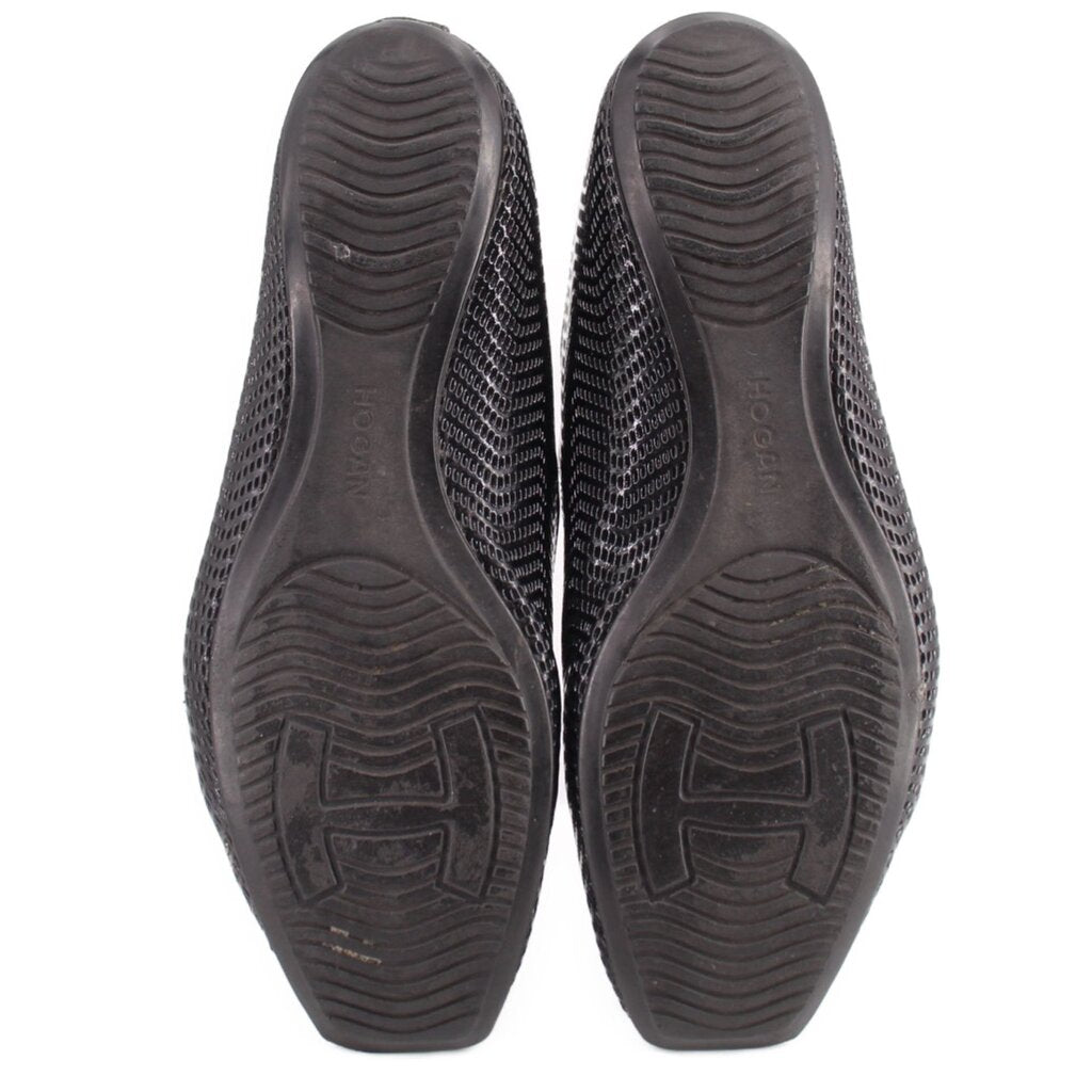 Black perforated flat shoe soles with textured tread and logo
