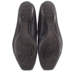 Black perforated flat shoe soles with textured tread and logo