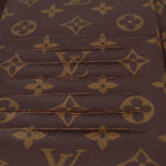 LOUIS VUITTON Voyage organizer wallet close-up of brown monogram canvas texture and stitching.