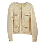 Cream knit jacket with front button placket, patch pockets, and decorative buttons