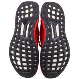 Black rubber outsoles with white traction cutouts for red knit sneakers.
