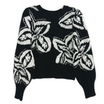 Black knit sweater with crew neck and large white graphic print, long sleeves.