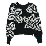 Black knit sweater with crew neck and large white graphic print, long sleeves.