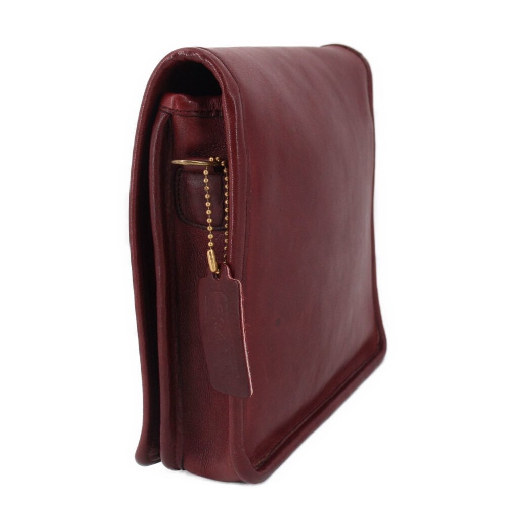 Oxblood leather compact bag with open side lining and hanging tag