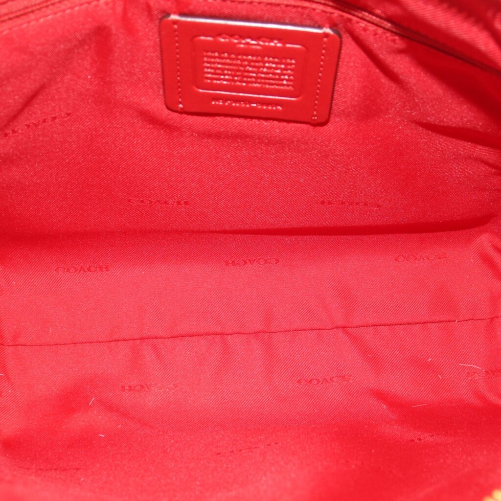 Red fabric-lined interior with small leather label and embossed COACH branding