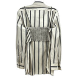 Back view of beige and black vertical striped top with collar and smocked panel