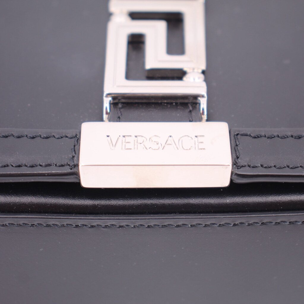 Black leather bag close-up of Versace branded front lock