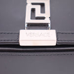 Black leather bag close-up of Versace branded front lock