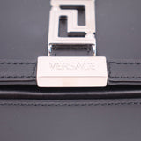 Black leather bag close-up of Versace branded front lock