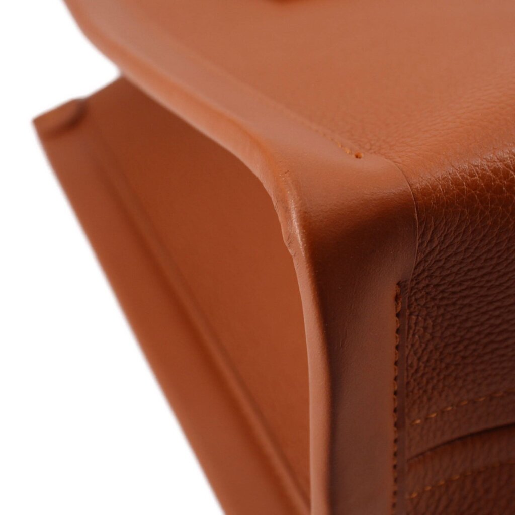 Close-up of brown leather tote bag corner with neat stitching and folded edge.