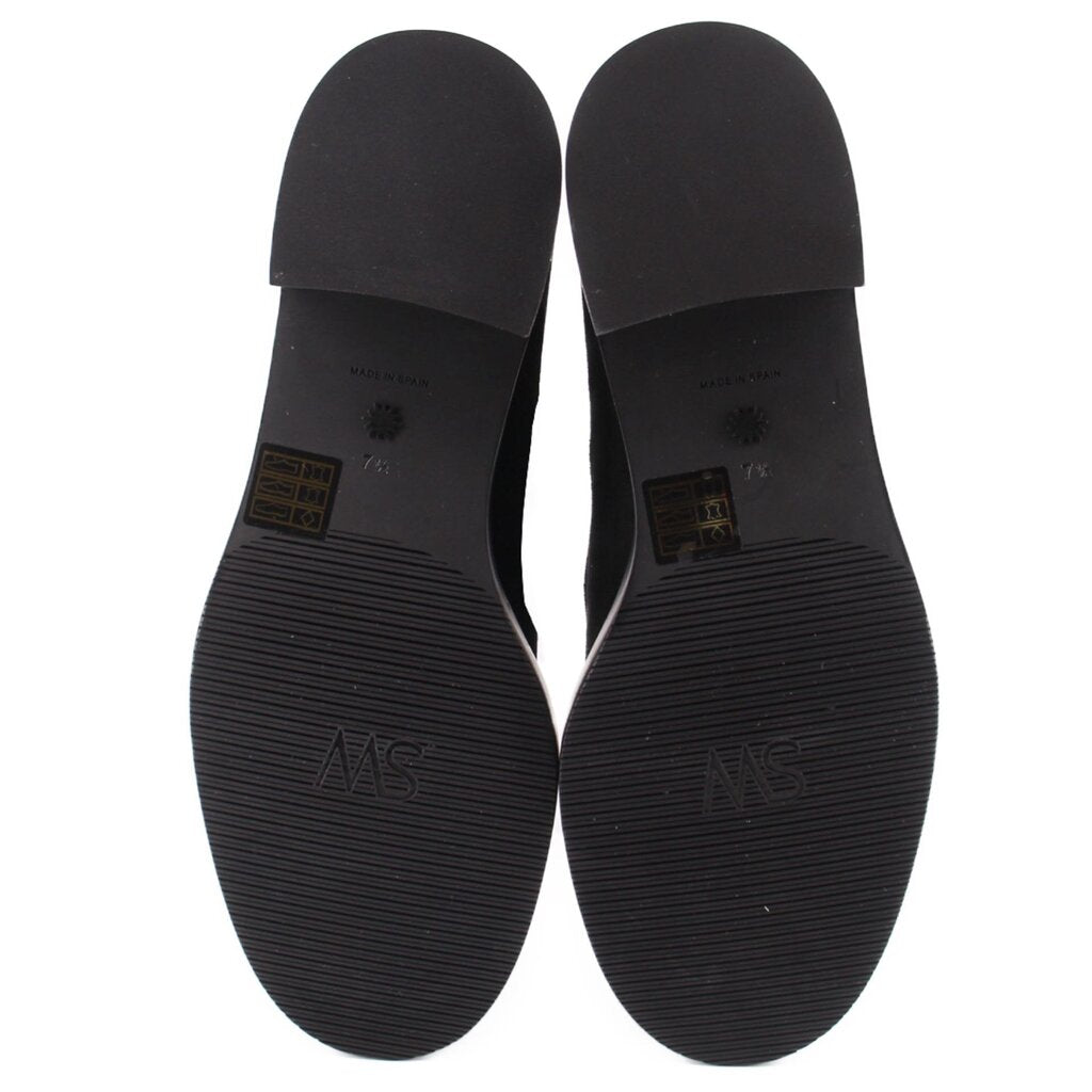 Black boot outsoles with tread pattern and heel branding on underside