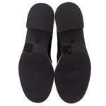 Black boot outsoles with tread pattern and heel branding on underside