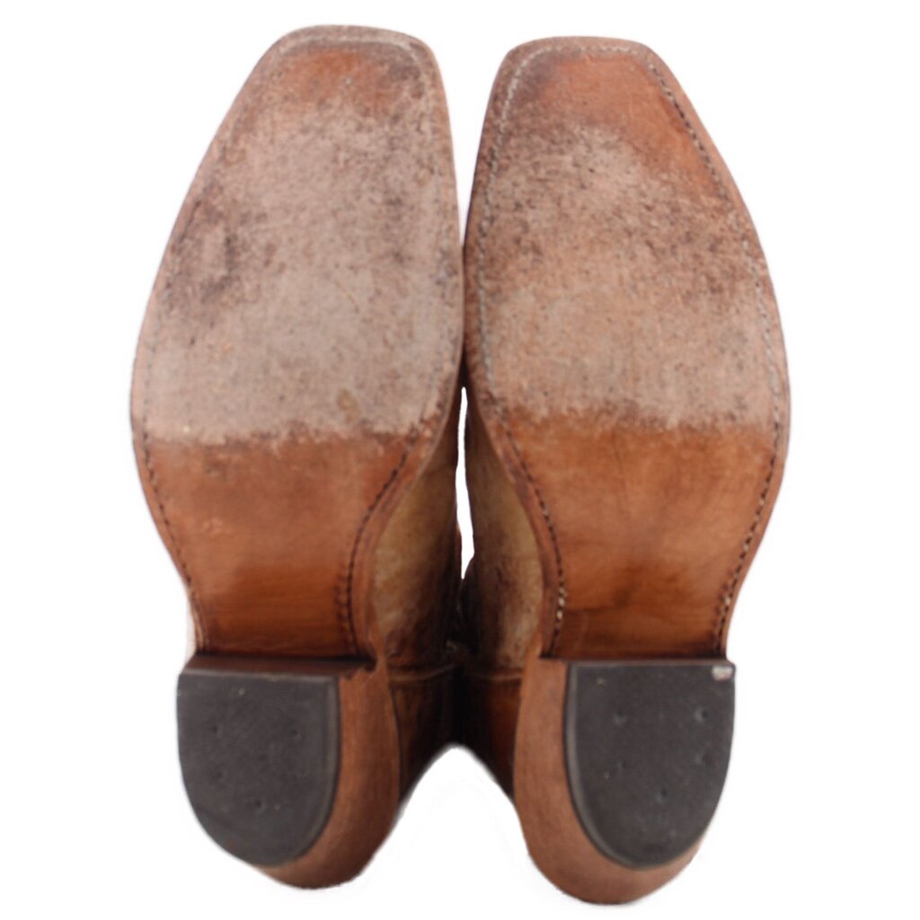 Brown cowboy boots showing heels and outsoles with stacked wood heel and dark pads