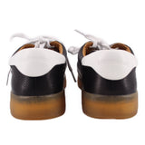 Back view of black leather sneakers with white laces and branded heel tab