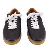 Pair of black leather sneakers with white lace-up detail and gum soles