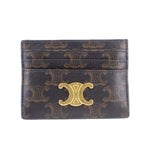 Brown designer card holder with gold-tone monogram emblem and embossed pattern
