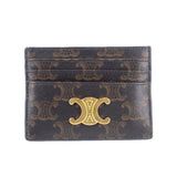 Brown designer card holder with gold-tone monogram emblem and embossed pattern