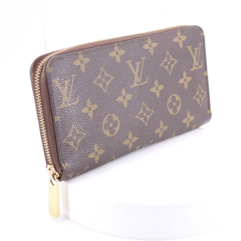 Monogram zip-around wallet angled view in brown with repeating gold pattern and zipper