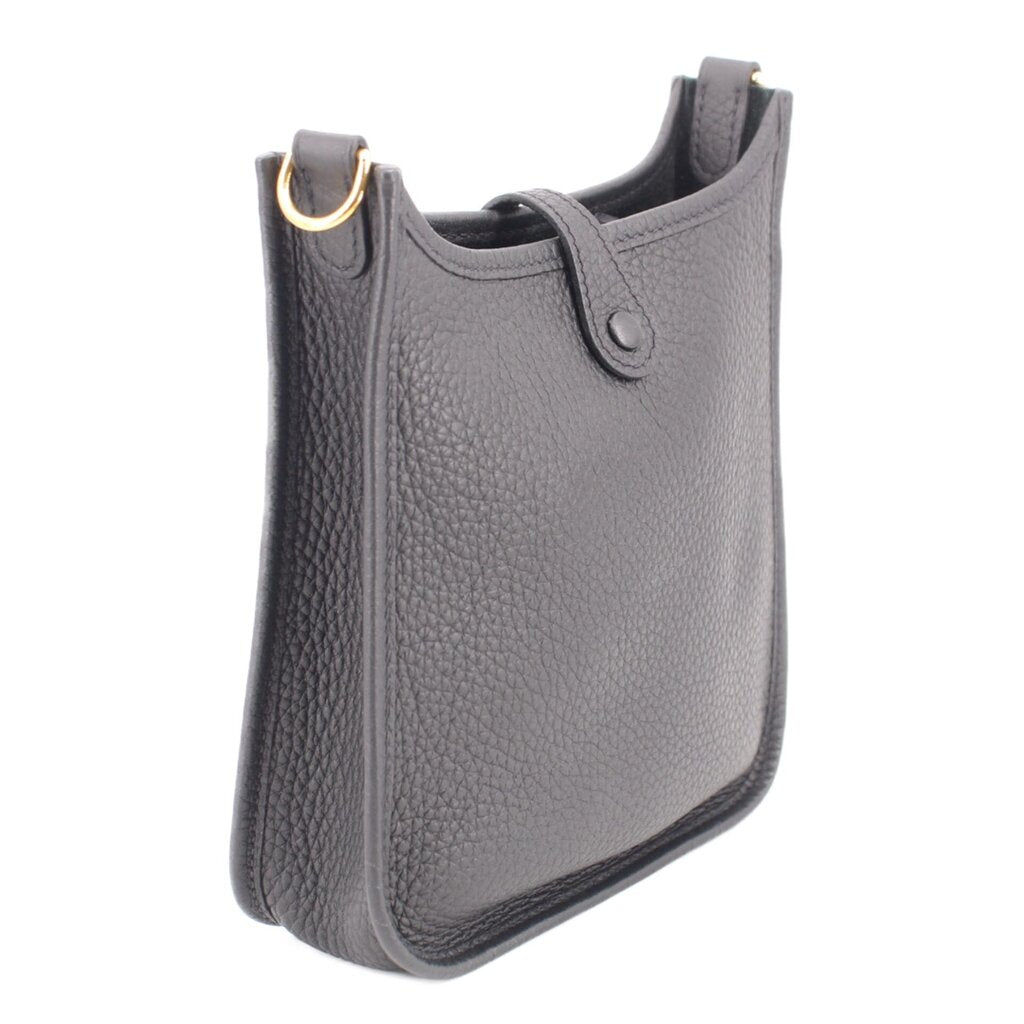 Small crossbody bag side view, textured leather, top loops with gold ring hardware, dark