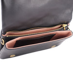 Black monogram crossbody bag interior with pink lining and gold zipper