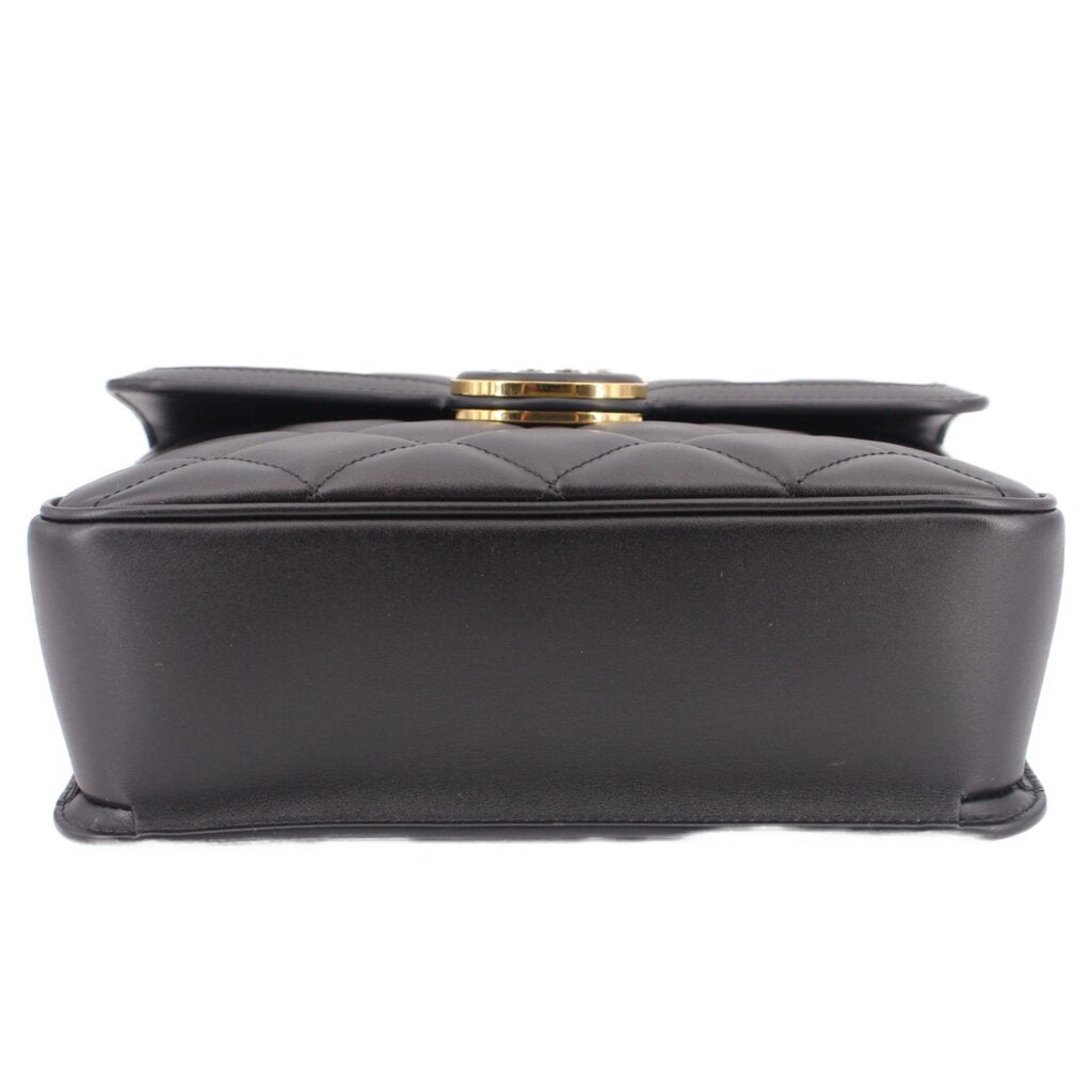 Black shoulder bag with structured top and round gold-tone turn-lock clasp.