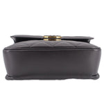Black shoulder bag with structured top and round gold-tone turn-lock clasp.