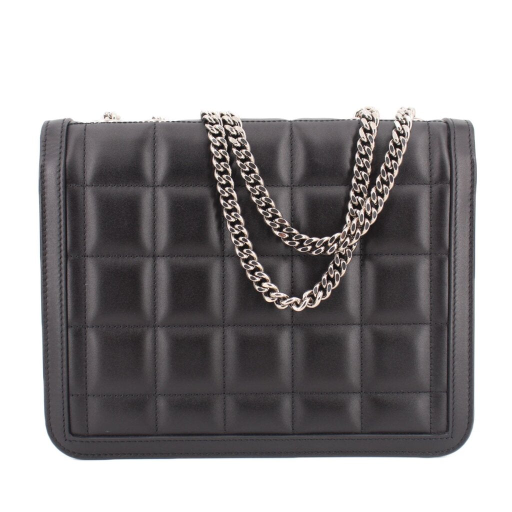 Black quilted shoulder bag with flap closure and silver-tone chain strap; front view.