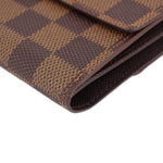Damier Ebene wallet edge close-up with folded seams and stitched trim.