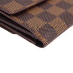 Damier Ebene wallet corner close-up showing stitched edge and textured canvas.
