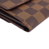 Damier Ebene wallet corner close-up showing stitched edge and textured canvas.