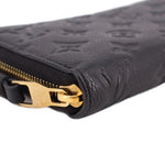 LOUIS VUITTON wallet close-up of gold zipper pull on black embossed leather