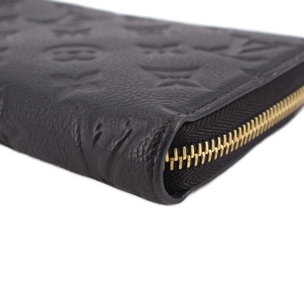 LOUIS VUITTON wallet close-up of gold zipper teeth on black embossed leather edge