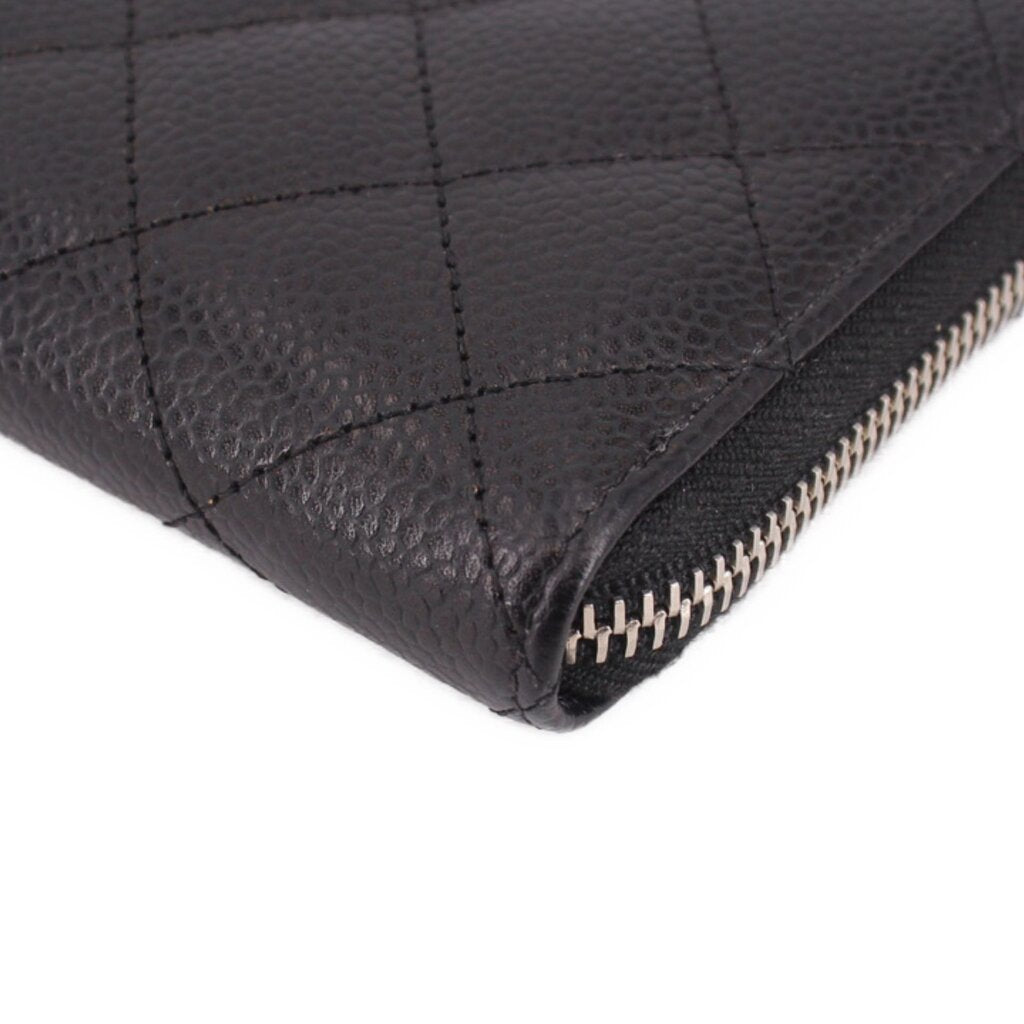 CHANEL black leather zip-around wallet corner close-up with stitched seams and zipper teeth