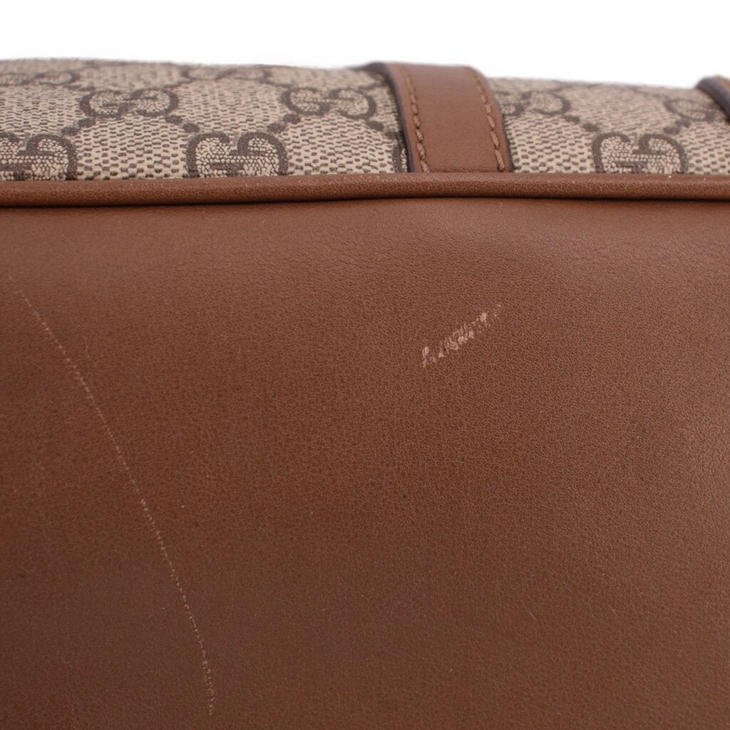 Brown leather panel with subtle diagonal seam on dome handle bag