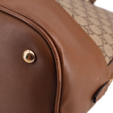 Brown leather side panel with gold-tone rivet and GG canvas trim on bag