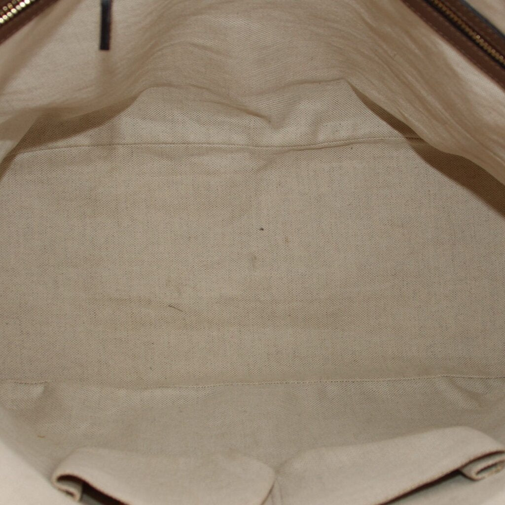 Cream fabric interior lining with seam detail inside dome handle bag