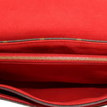 Red fabric interior of crossbody bag with zipper opening and visible stitching