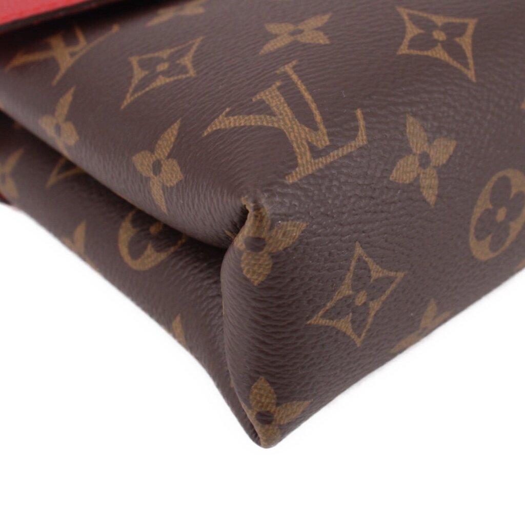 Close-up of monogram canvas corner with visible creasing on crossbody bag
